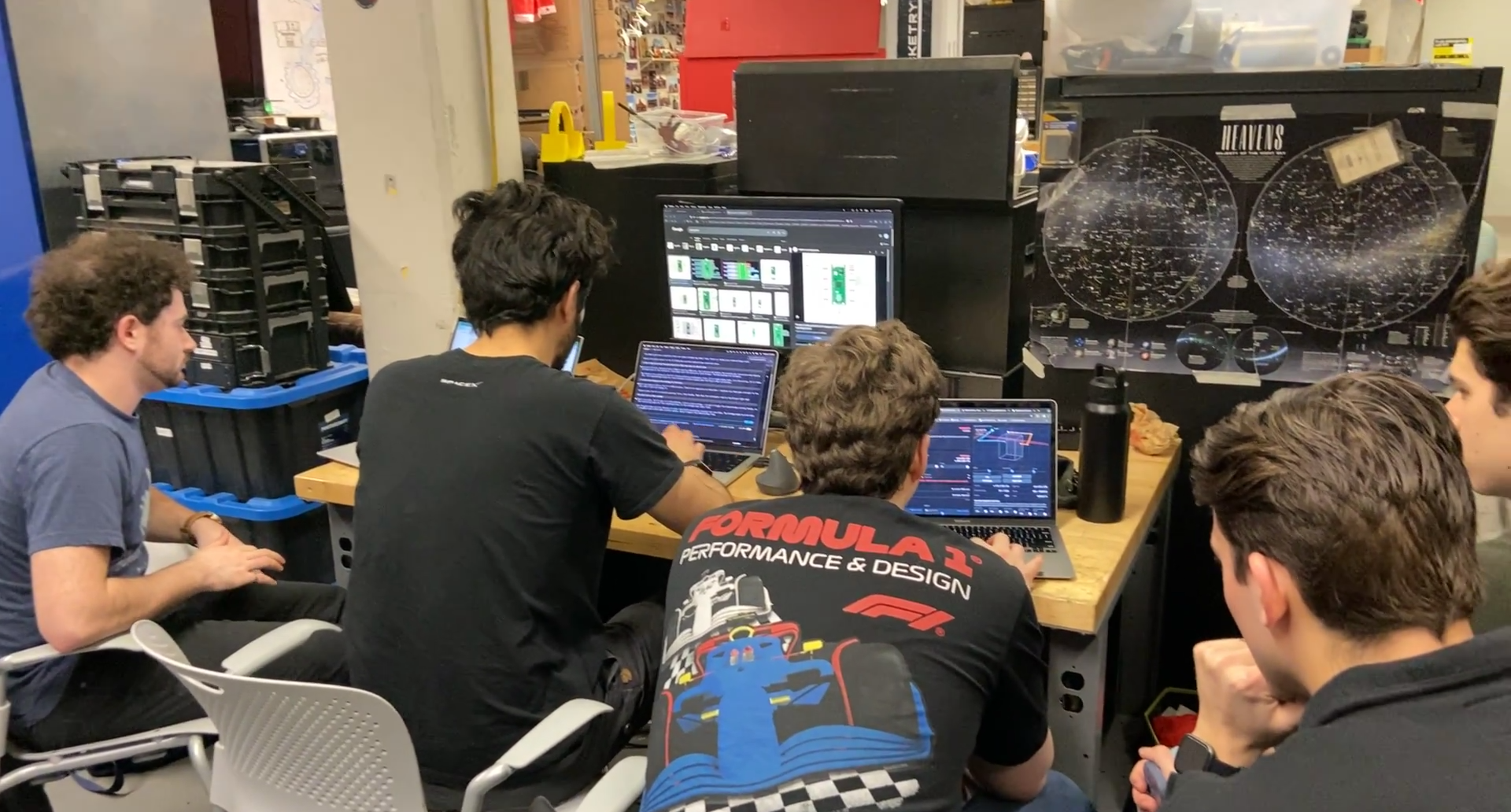 Engineering team collaborating around laptops in the lab